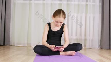 健身女孩聊天移动电话健身房地毯首页体育运动女孩少年智能手机坐着健身地毯打破首页培训